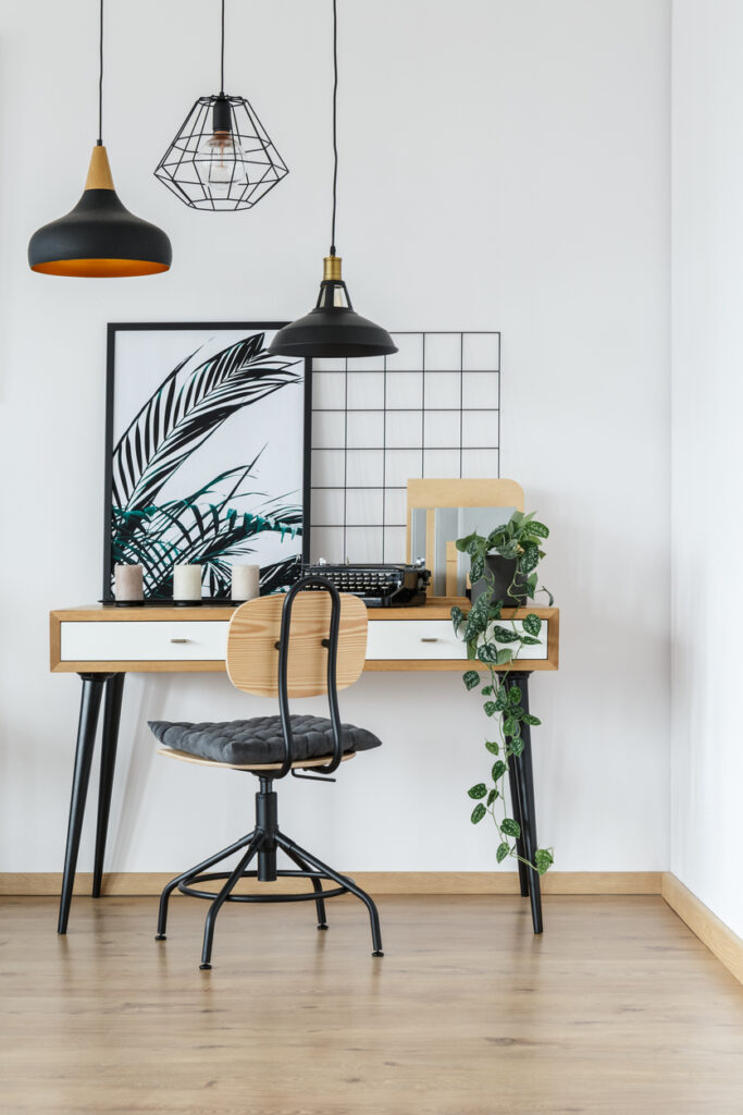 Industriálne bývanie v útulnom bielom interiéri domácej kancelárie s vintage písacím strojom, rastlinou a plagátom