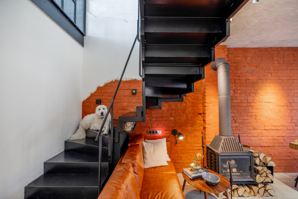 Tehlová stena, betónová podlaha, kovové schody