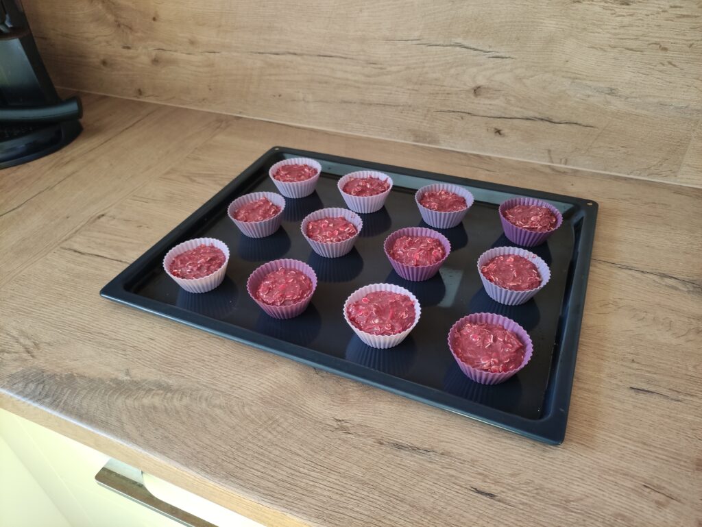 muffinové formičky na plechu naplnené cestom na domáce pamlsky pre psa 