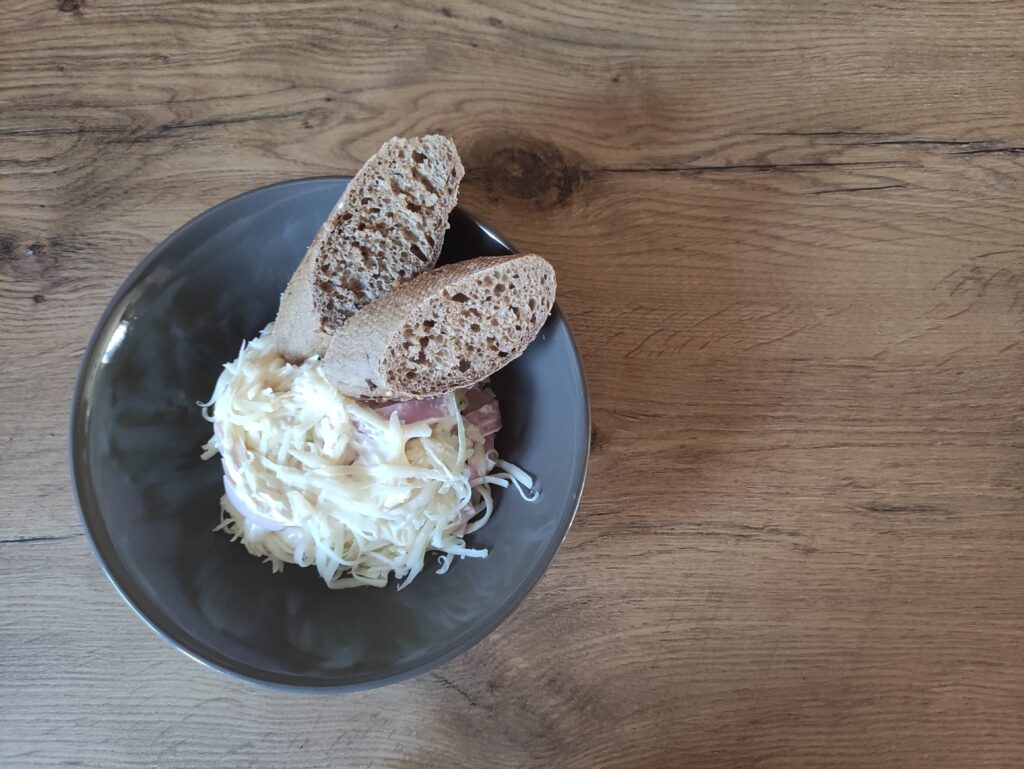 prekladaný šalát na tanieri s pečivom