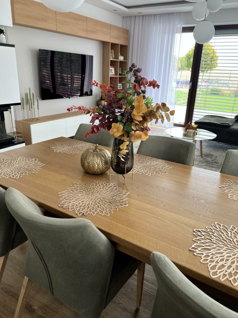 jesenné dekorácie v obývačke s jedálenským stolom a zelenými jedálenskými stoličkami