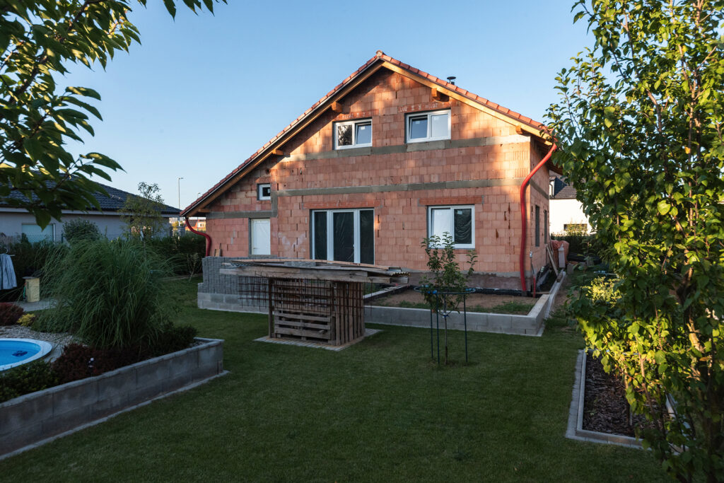 Rodinný dom stavaný svojpomocne z tehál HELUZ, pohľad na zadnú časť domu so záhradou.