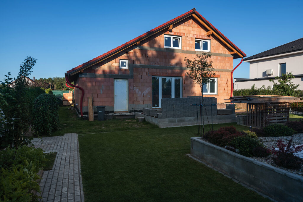 Rozostavaný rodinný dom z jednovrstvového muriva HELUZ, pohľad na hrubú stavbu zo záhrady.