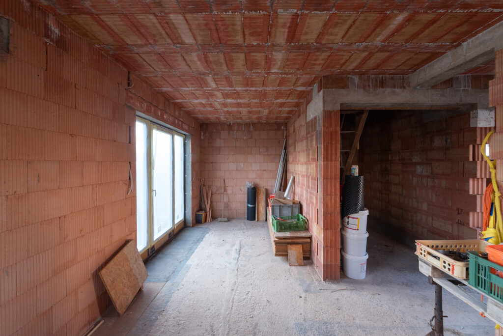Interiér stavby s jednovrstvovým tehlovým murivom HELUZ, miestnosť vo fáze hrubej stavby.
