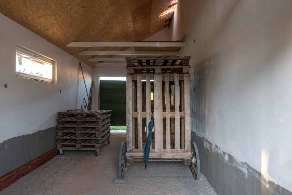 Pohľad do garáže s pojazdným lešením pripraveným na dokončovacie práce svojpomocne.