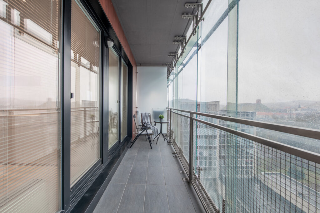 presklený moderný balkón so sedením pripravený na oddych