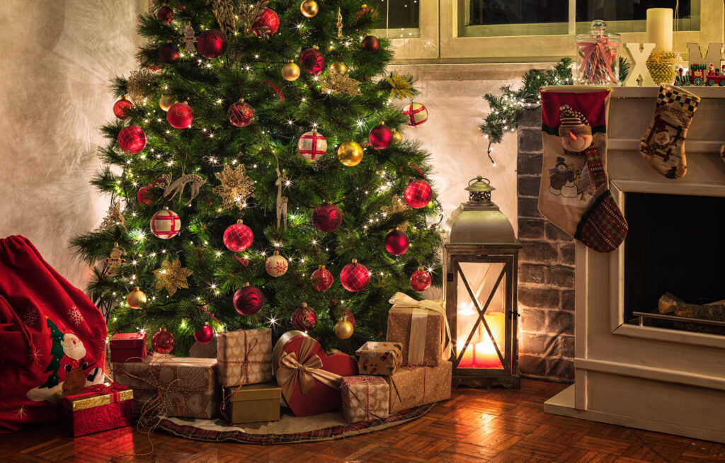 vianočná atmosféra doma s ozdobeným stromčekom a darčekmi pri krbe
